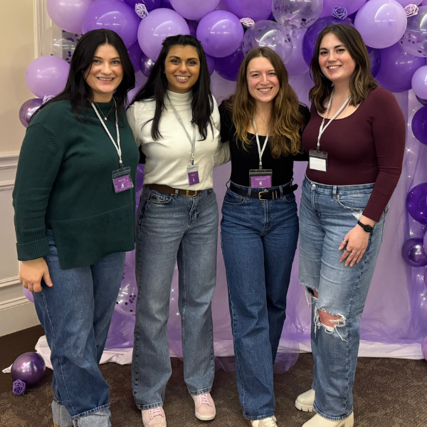 The leadership team that put together the event. Four women standing in front of purple balloons.